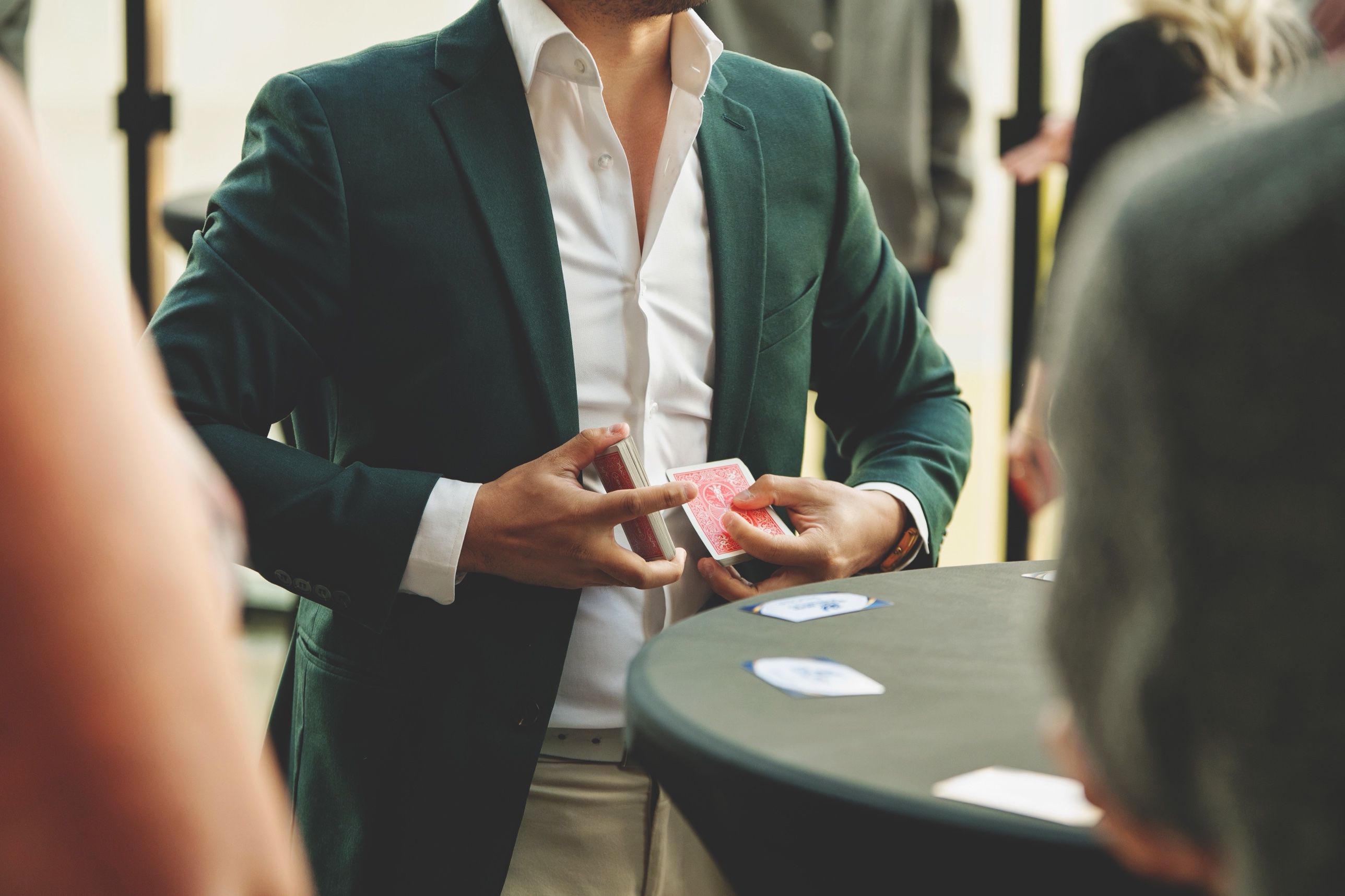 Jason Wong performing close-up card magic for guests at a corporate reception